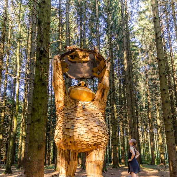 Ein großer hölzerner Troll im Wald.