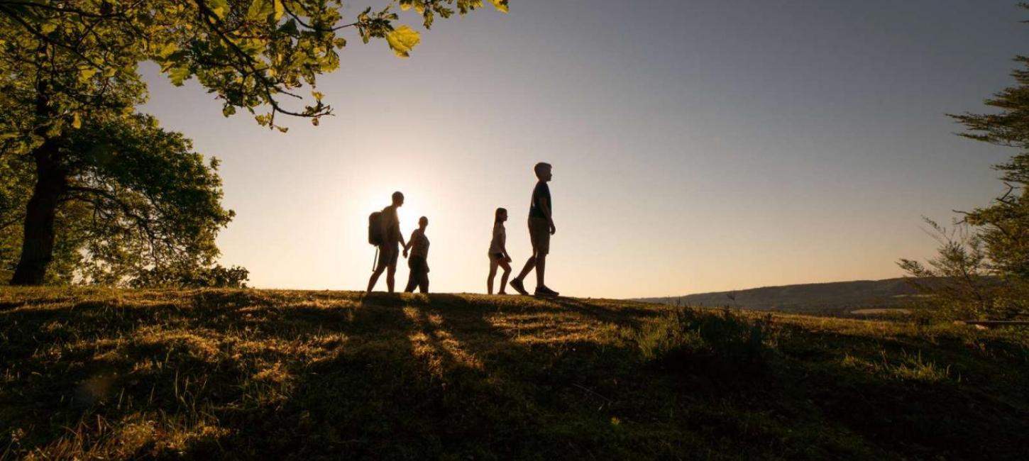 Familie spaziert im Sonnenuntergang auf dem Zuckerhut